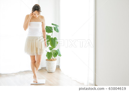 A woman measuring weight 63804619