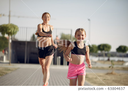 Mother with daughter doing sport in a summer park 63804637
