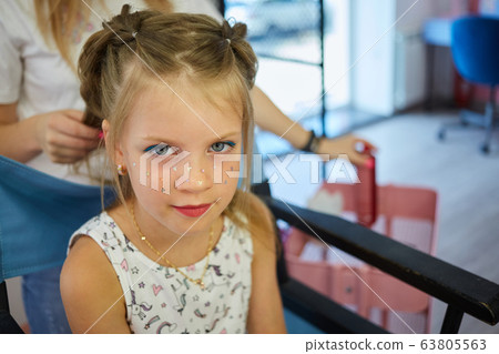 Hairdressing services. Reating hairstyle. Hair styling process. Children hairdressing salon Hairdressing services. Reating hairstyle. Hair styling process. Children hairdressing salon 63805563