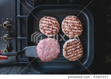 Fresh meat cutlets in a grill pan. Juicy meat steak in a pan. Cooking a burger at home. Delicious and healthy food concept. Fresh meat cutlets in a grill pan. Juicy meat steak in a pan. Cooking a burger at home. Delicious and healthy food concept. 63805831