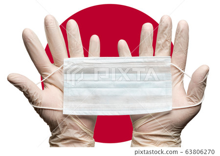 Nurse holding respiratory face mask in two hands in white gloves on background flag of Japan 63806270