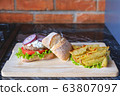 Homemade burger with beef chop, tomato, lettuce and dorblu blue cheese sauce. Serve on a wooden kitchen board on a table made of natural stone. Background image. 63807097