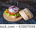 Homemade burger with beef chop, tomato, lettuce and dorblu blue cheese sauce. Serve on a wooden kitchen board on a table made of natural stone. Background image. 63807098