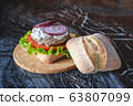 Homemade burger with beef chop, tomato, lettuce and dorblu blue cheese sauce. Serve on a wooden kitchen board on a table made of natural stone. Background image. 63807099