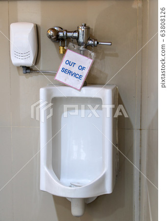 Broken public toilets. Damaged urinal with a sign Broken public toilets. Damaged urinal with a sign 63808126