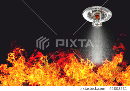 Image of Fire Sprinklers Spraying with fire background. Fire sprinklers are part of an overall safety protocol for fire and life safety. 63808381