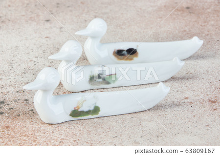 Antique porcelain duck cutlery stand on concrete 63809167