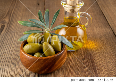 Green olives with olive branch in a small wooden Green olives with olive branch in a small wooden 63810076