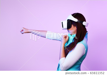 Woman is using virtual reality headset, playing game and fighting. 63811352
