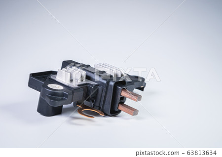 Automotive relay voltage regulator voltage regulator. New electric car spare parts on gray background Automotive relay voltage regulator voltage regulator. New electric car spare parts on gray background 63813634