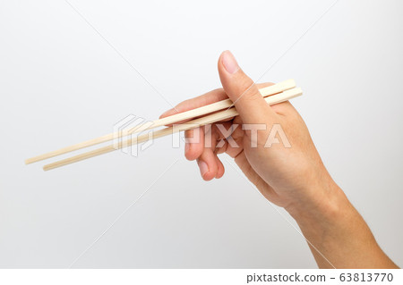 Hand holding chopsticks Hand holding chopsticks 63813770