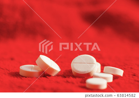 pills on red blurred background 63814582
