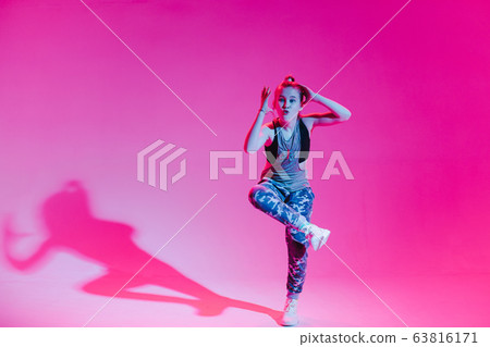Young stylish girl dancing in the Studio on a colored neon background. Music dj poster design. Young stylish girl dancing in the Studio on a colored neon background. Music dj poster design. 63816171