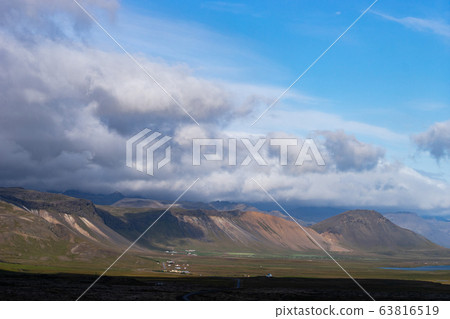 Icelandic landscape with mountains, blue sky and green grass on the foreground. West fjord part Icelandic landscape with mountains, blue sky and green grass on the foreground. West fjord part 63816519
