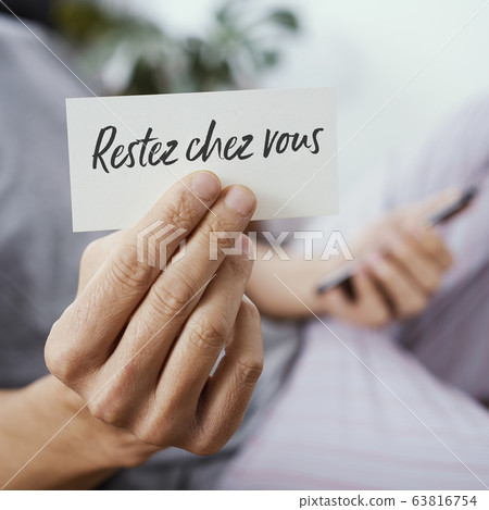 man showing the message stay at home in french man showing the message stay at home in french 63816754