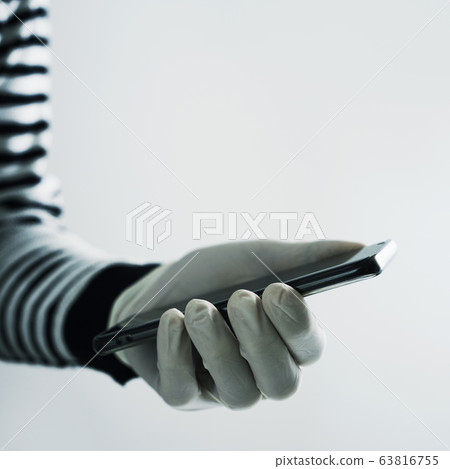 man wearing latex gloves using his smartphone 63816755