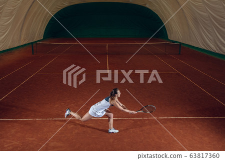 Young caucasian professional sportswoman playing tennis on sport court background Young caucasian professional sportswoman playing tennis on sport court background 63817360