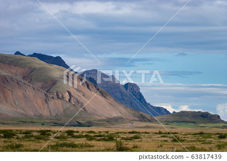 Icelandic landscape with mountains, blue sky and green grass on the foreground. West fjord part Icelandic landscape with mountains, blue sky and green grass on the foreground. West fjord part 63817439