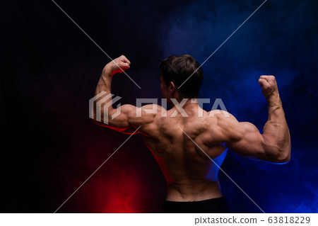 Muscular man showing muscles isolated on the black background.healthy lifestyle  63818229