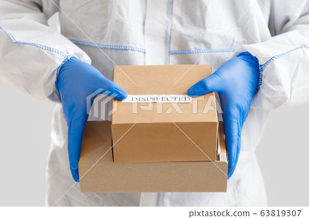 Man holding boxes in gloves. Delivery service under quarantine Man holding boxes in gloves. Delivery service under quarantine 63819307