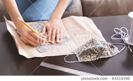 Isolation at home. Woman makes homemade protective mask 63819390