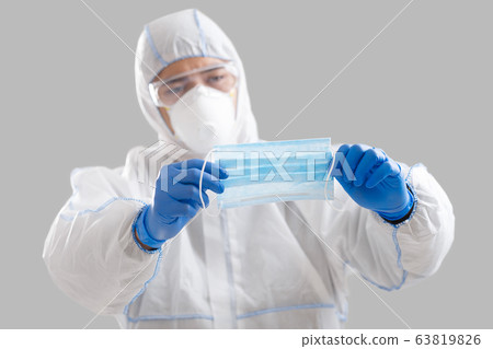Asian man holds protective mask for patient Asian man holds protective mask for patient 63819826