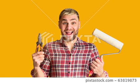 Guy holds pliers and roller in his hands 63819873