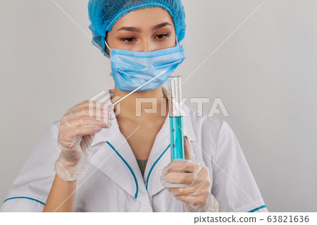 Portrait of young woman with swab and test tube. Portrait of young woman with swab and test tube. 63821636