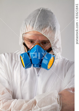 Scared man wearing protective clothing and respiratory mask. Scared man wearing protective clothing and respiratory mask. 63821641