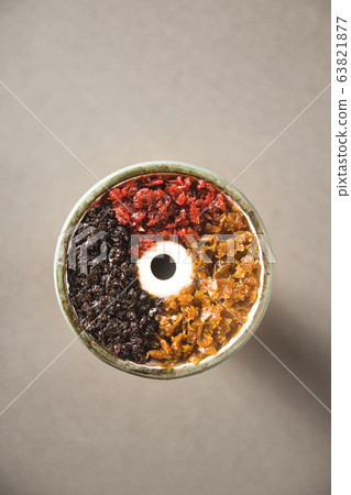 Multicolored tobacco in a filled bowl of hookah. 63821877