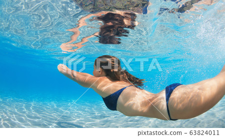 Active young woman swim underwater in tropical 63824011