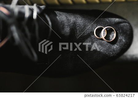 Set of mans fashion shoes with two golden wedding rings 63824217