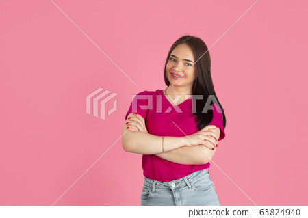 Monochrome portrait of young caucasian brunette woman on pink background 63824940