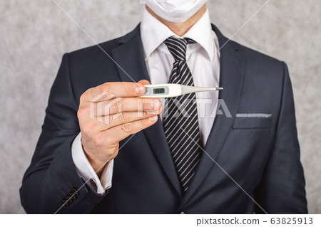 A man in a suit and tie holds in his hands an 63825913