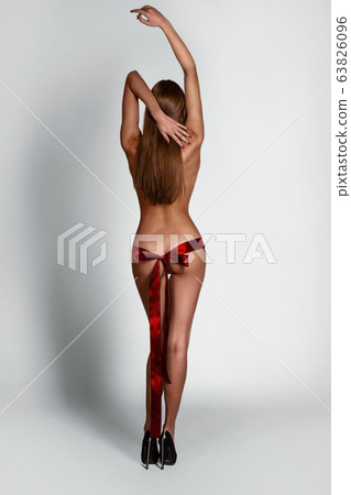 Sexy slim lady with red ribbon on her butt 63826096