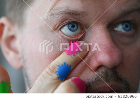 Man touches his eyes with microbes coronavirus Man touches his eyes with microbes coronavirus 63826966