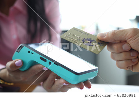 Man holds contactless credit card to terminal 63826981