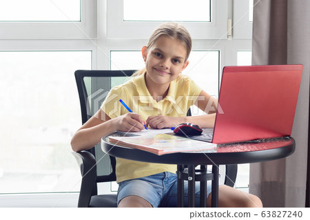 The girl at the table at home does homework and 63827240