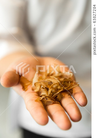 chef holding smoked tuna slices in his hands. Bonito Flakes in chef hands. chef holding smoked tuna slices in his hands. Bonito Flakes in chef hands. 63827284