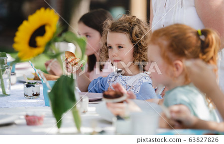 Small children eating on summer garden party, birthday celebration concept. Small children eating on summer garden party, birthday celebration concept. 63827826