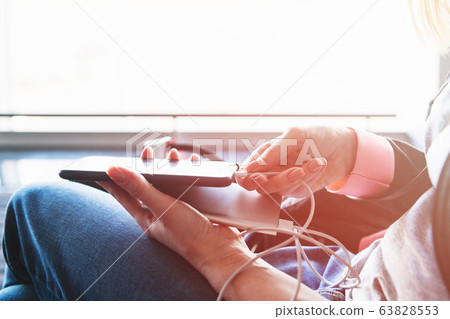 Woman hand connect power bank to smartphone 63828553