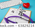 Medical stethoscope and red heart lying on cardiogram chart closeup. Medical help, prophylaxis, disease prevention or insurance concept. Cardiology care. 63829214