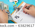 Male doctor or pharmacist holding money in hand and writing prescription on a special form. medical costs and healthcare payment concept. 63829617