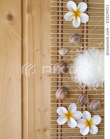 Shells and tiare flowers on the wooden background Shells and tiare flowers on the wooden background 63829951