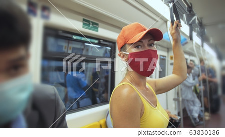 Woman travel caucasian ride at overground train airtrain with wearing protective medical mask. Girl tourist at airtrain with respirator. People mask. Woman travel caucasian ride at overground train airtrain with wearing protective medical mask. Girl tourist at airtrain with respirator. People mask. 63830186