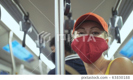 Woman travel caucasian ride at overground train airtrain with wearing protective medical mask. Girl tourist at airtrain with respirator. People mask. Woman travel caucasian ride at overground train airtrain with wearing protective medical mask. Girl tourist at airtrain with respirator. People mask. 63830188