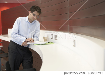 Businessman in office making notes in workbook 63830799