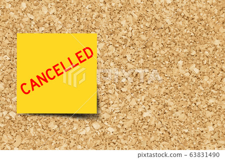 Yellow note with word cancelled on cork board Yellow note with word cancelled on cork board 63831490