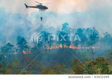 Helicopter dumping water on forest fire Helicopter dumping water on forest fire 63832094