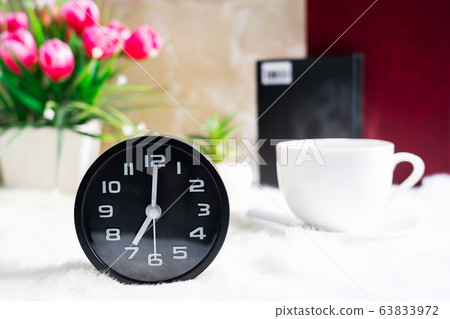 Black clock and cup of coffee 63833972